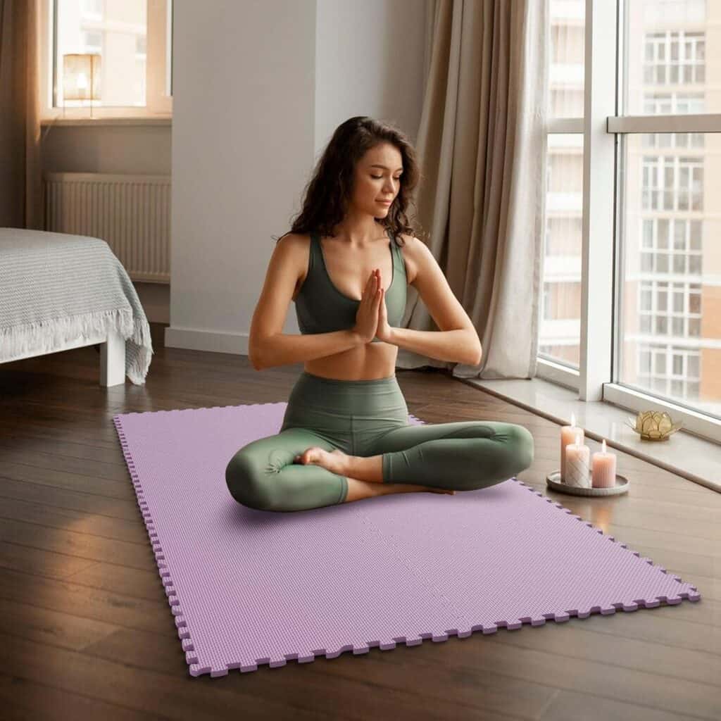 Girl sitting cross-legged on interlocking foam floor mats for home gym.
